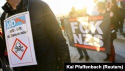 پلاکاردی که AfD را سمتی برای دموکراسی توصیف می‌کند در تجمع مخالفان در دهمین سالگرد تأسیس این حزب در فوریه ۲۰۲۳