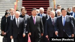 Си Цзинпин жана Шанхай кызматташтык уюмуна (ШКУ) байкоо салган башка мамлекеттердин лидерлери, аймактык жана эл аралык уюмдардын өкүлдөрү ШКУ кеӊешинин Бишкектеги 19-отурумунда сүрөткө түшүп жатат. Кыргызстан, 2019-жыл, 14-июнь.