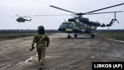 Пілот підходить до свого гелікоптера на українській військовій авіабазі поблизу лінії фронту в Херсонській області