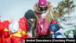 Voluntari SMURD oferă alimente și dulciuri refugiaților care trec în România prin vama Siret în data de 26 februarie 2022, la două zile de la izbucnirea războiului.