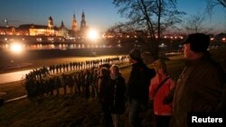 Възпоменание за бомбардировките, включващо жива верига на брега на река Елба в Дрезден. От другата страна на реката се вижда възстановеният град. 13 февруари 1945 г.