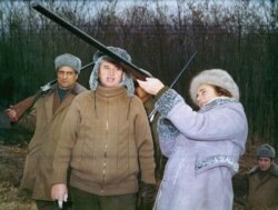 Nicolae Ceausescu, sa zavijenim prstima, gleda suprugu Elenu kako puca iz puške tokom novogodišnjeg lova 1976. godine.