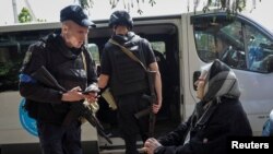 Поліцейський спілкується з місцевими жителями під час евакуації у місті Вовчанськ Харківської області, Україна, 12 травня 2024 року