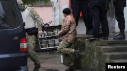 Посередині один із полонених моряків, які були захоплені Росією після нападу на українські кораблі