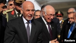 افغان ولسمشر محمد اشرف غني ته پر چکلاله هوايي ډګر د پاکستاني وزیر اعظم بهرنو چارو سلاکار سرتاج عزیز هرکلی ورته وايي.
