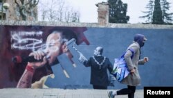 Дубалда "Пабло Хаселге боштондук!" деп жазылган жана аны мурдагы падыша Хуан Карлос өчүрүп жаткандай тартылган. Автор - Синта Видал айым. Кардедеу кыштагы. Каталония. 2021-жылдын 15-февралы.