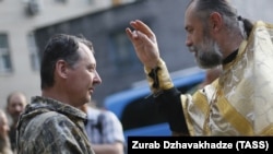 Священик благословляє російського полковника Ігоря Гіркіна (Стрєлкова), який на той час був одним із ватажків угруповання «ДНР», що визнане в Україні терористичним. Окупований Донецьк, 10 липня 2014 року