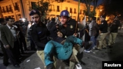 A policeman carries one of the injured after a blast in Lahore on February 13.