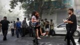 Мужчына нясе параненую дзяўчынку пасьля выбуху ў цэнтры Тэгерану 15 чэрвеня 2025 падчас ізраільскіх удараў па цэлях ува ўсім Іране.