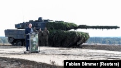 Канцлер Німеччини Олаф Шольц виступає на тлі танка Leopard 2 під час візиту на військову базу у Бергені. Німеччина, 17 жовтня 2022 рок