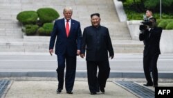 Дональд Трамп в бытность президентом США и лидер Северной Кореи Ким Чен Ын рядом с демаркационной линией, разделяющей Север и Юг. Пханмунджом, 30 июня 2019 года.