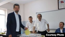 Turkey - Garo Paylan (L), an ethnic Armenian candidate of the People's Democratic Party (HDP), casts a ballot at a polling station in Istanbul, 7Jun2015.