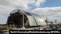 Загальний вигляд проммайданчику ЧАЕС: за аркою ​– четвертий енергоблок. Квітень 2015 року
