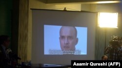 Pakistani journalists watch a video showing Indian national Kulbushan Jadhav in 2016.