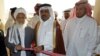 FILE: Former Qatari Assistant Minister for Foreign Affairs Ali bin Fahd al-Hajri (C) cuts the ribbon alongside a member of the Taliban's office Jan Mohammad Madani (L) at the opening ceremony of the new Taliban political office in Doha in 2013.