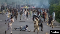 Anti-government protesters run after police personnel in Islamabad, September 1, 2014.