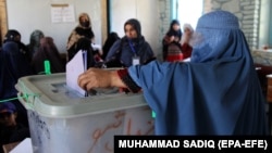 An Afghan woman casts her vote during parliamentary elections in Kandahar on October 27.